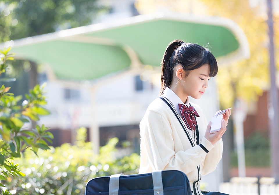 待ち時間に単語カードで勉強する女子高生のイメージ
