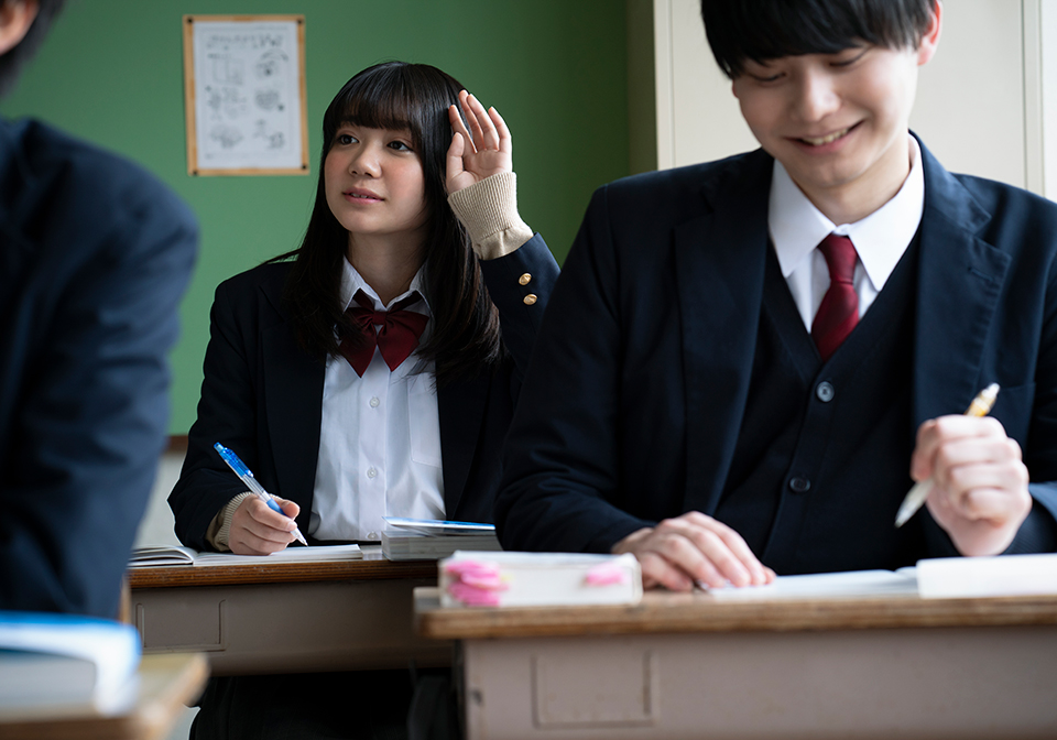 授業で手を上げている女子高生のイメージ